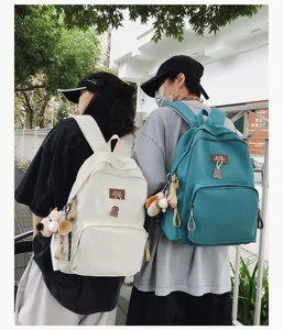 Outdoor lifestyle detail showing campus backpacks worn by models, featuring clean style and utility.