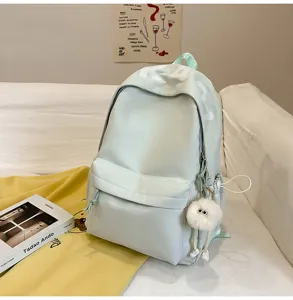 Casual light green backpack for women, large capacity daily school bag with cute plush pendant.