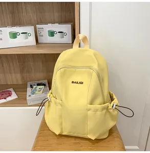 Casual yellow waterproof backpack detail with front zipper pocket and side drawstring pockets.