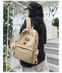 Detailed lifestyle shot of a minimalist campus canvas backpack worn by a student outdoors.