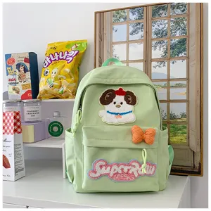 Close-up of cute green backpack featuring fluffy dog patch and bow detail for daily school use.