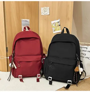 Detailed view of casual canvas backpacks in red and black colors with handy front pockets.