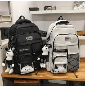Detail view of the student school backpack featuring multi-pocket design and cute doll pendant.