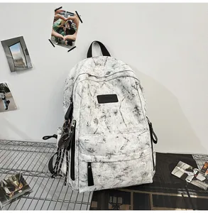 Tie-dye canvas backpack detail view, front zipper pocket, brand badge for daily school use.