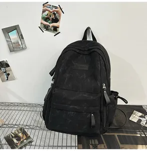Black canvas backpack detail showcasing retro fabric texture and practical multi-pocket layout.