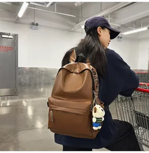 Stylish brown PU leather backpack for women, waterproof casual daypack with cute pendant.