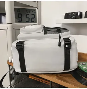 Detail view of a large-capacity multi-functional student school bag in grey color with mesh pockets.