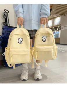 Cute yellow canvas backpack for teenage girls with lovely bear patch and casual style.
