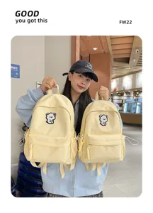 Detailed view of cute ins style yellow school backpack with lovely bear patch embroidery.