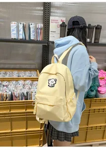 Casual canvas school backpack in soft yellow featuring cute bear embroidery design for daily use.