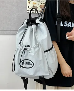 Detail view of the lightweight grey drawstring backpack with black straps and brand logo.