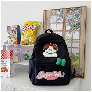 Detailed shot of the cute black school backpack showing unique puppy embroidery and patches.
