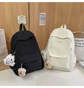 Detail view of casual canvas backpack with cute plush keychain, perfect for daily campus use.
