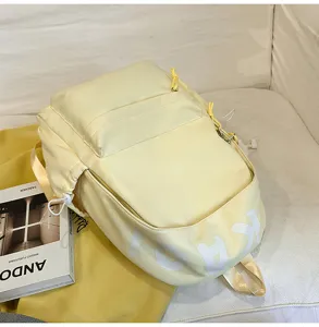 Detail view of the stylish yellow casual backpack showing soft fabric and front pocket.