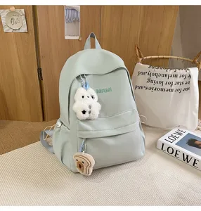 Casual campus backpack for women and students, lightweight travel school bag with cute pendants.