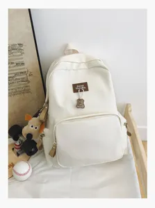 Casual canvas backpack with large capacity, cute bear charm and minimalist student bookbag.