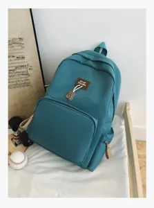 Detail view of the solid color casual backpack with front pocket, stylish daily school bag for students.