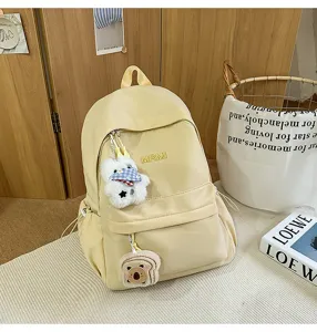 Casual yellow campus backpack with cute plush pendants, ideal for daily school and travel use.