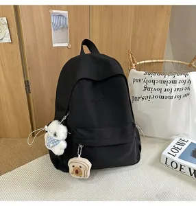 Detailed view of Japanese style ins casual black school backpack with cute plush pendants.