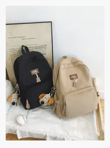 Casual canvas student school backpack in black and khaki with cute bear and dog charms.