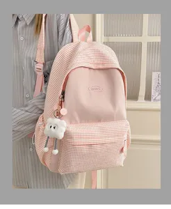 Pink plaid school backpack for teenage girls, cute aesthetic casual student bookbag with doll pendant.