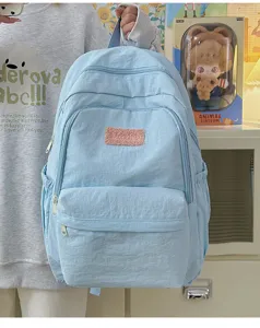 Light blue casual backpack for women, stylish minimalist school bag for daily use and travel.