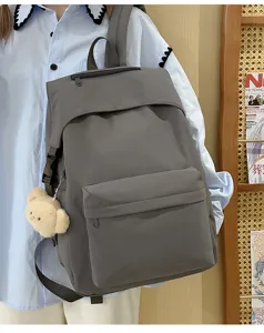 Casual gray nylon backpack detail view with cute bear pendant and daily campus style design.