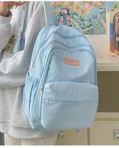 Close-up view of the light blue casual student backpack highlighting its front pocket and soft fabric.