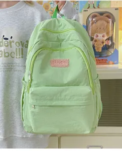 Green minimalist casual backpack detail view, lightweight student school bag with multi pockets.