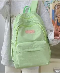 Light green casual backpack detail, minimalist style, multi-pocket daily school bag.