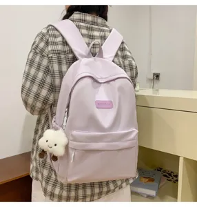 Detailed view of the casual light purple school backpack with front pocket and charm.