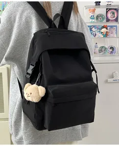 Detail view of the black nylon casual backpack with cute bear pendant and side buckle.