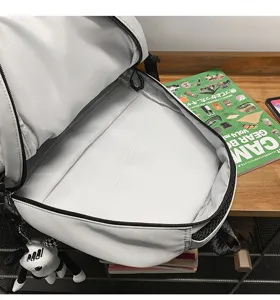 Detailed view of large capacity white school backpack interior with zipper and pendant