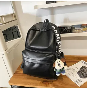 Black PU leather backpack for women, stylish minimalist student bookbag with cute dog pendant.