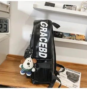 Black PU leather backpack for women, waterproof casual computer school bag with cute dog pendant.