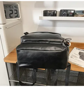 Classic black PU leather backpack for women, casual minimalist school book bag daily use.