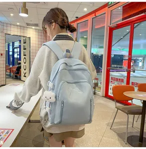 Detailed view of cute Japanese style blue school backpack with bow embroidery and cloud charm.