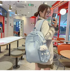 Light blue cute school backpack for women, large capacity travel daypack with bow and cloud pendant.