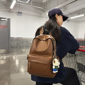 Stylish brown PU leather backpack for women, casual waterproof school bag with cute pendant.