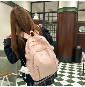 Pink cute school backpack for teenage girls, large capacity travel daypack with bow detail.