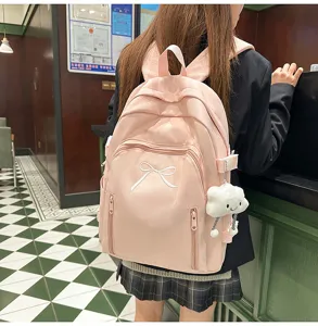 Japanese cute pink school backpack for girls, large capacity travel bag with bow and pendant.