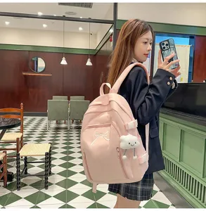 Cute pink school backpack for teen girls, featuring bow embroidery and sweet cloud pendant.