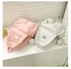 Japanese style minimalist solid color campus backpack with cute bear pendant and drawstring.