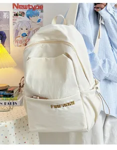 Detail view of simple minimalist white canvas backpack with large capacity and front pocket.