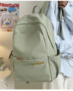 Detail shot of the minimalist light green backpack showcasing durable fabric and side pocket.