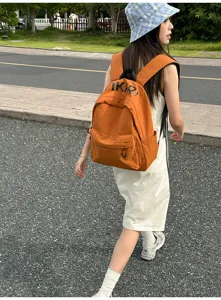 Outdoor lifestyle shot showing the casual Korean style orange canvas backpack worn by model.