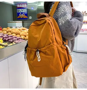 Casual solid color nylon backpack showing side pocket details, large capacity travel daily use.