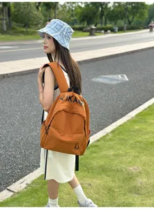 Outdoor lifestyle detail view of casual orange canvas backpack, stylish casual everyday school bag