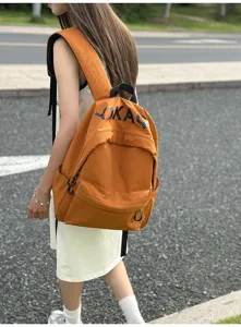Casual orange nylon backpack outdoor detail view, stylish casual student daypack with pockets.
