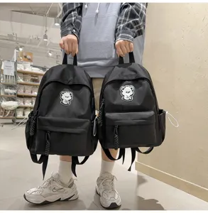 Detailed view of stylish black casual student backpack with cute bear patch for daily use.